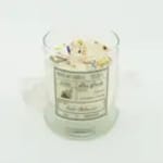 Clear glass candle jar with a floral-scented candle and printed label