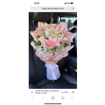 Large bouquet of pink lilies, roses, and white filler flowers wrapped in pink paper with ribbon