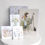 Four floral-themed notebooks and cards with watercolor garden illustrations