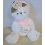 White teddy bear with a pink flower headband and bow