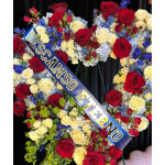 Large floral wreath with red, white, and blue roses and a diagonal sash reading "DESCANSO ETERNO".