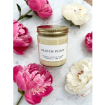 Peony-scented candle in a glass jar surrounded by pink and white peonies