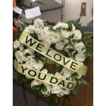 Round white rose sympathy wreath with yellow WE LOVE YOU DAD ribbons on a stand