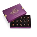 Open purple box of assorted chocolate truffles with lid partially covering the tray