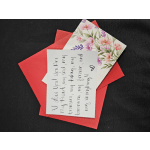 Red envelope with a floral card and handwritten note