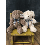 Two plush teddy bears with plaid bows sit on a small yellow stool.