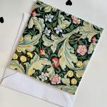 Floral patterned card with cream leaves and small flowers on a dark background