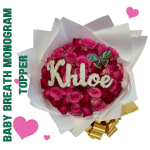 Pink rose bouquet wrapped in white paper with a gold ribbon