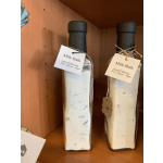 Two milk bath bottles with tags on a wooden shelf