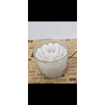 White lotus-shaped candle in a clear glass holder