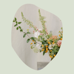 Loose floral arrangement with peach and white blooms in a vase