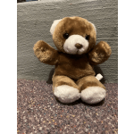 Brown and white teddy bear plush toy sitting on carpet