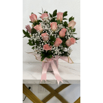 Pink roses and white baby's breath arranged in a pink box with ribbon.