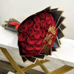 Bouquet of red roses wrapped in black paper with gold butterfly accents