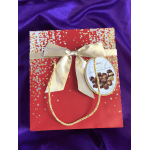 Red gift box of assorted chocolates with a gold bow and rope handle