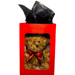 Teddy bear in a red gift box with black tissue paper