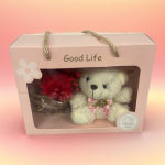 Gift box with a teddy bear and red flower bouquet