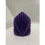 Purple shell-shaped candle on a white surface