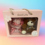Pink gift box with a small bouquet and teddy bear