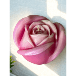Close-up of a pink rose-shaped candle on a patterned surface