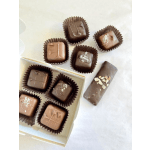 Assorted chocolate truffles in paper cups and a chocolate bar in a box