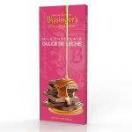 Pink boxed milk chocolate dulce de leche bar with caramel pouring over stacked chocolate pieces