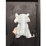 Light blue plush elephant toy being held in front of a dark door