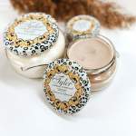 Three scented candles in glass jars with leopard-print lids