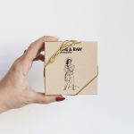 Hand holding a small box of chocolate tied with gold cord