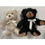 Two plush teddy bears with ribbon bows, one beige and one black.