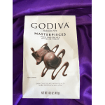 Bag of Godiva dark chocolate ganache heart candies on purple fabric