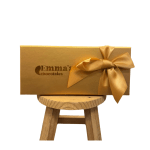 Gold chocolate gift box with a satin ribbon on a wooden stool