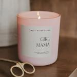 Pink glass candle labeled Girl Mama with a lit wick