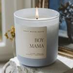 Lit white candle in a glass jar labeled Boy Mama