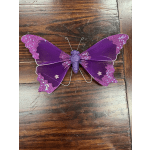 Purple glitter butterfly decoration on a wooden surface