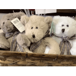 Three plush teddy bears in a wicker basket with plaid bows