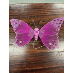 Pink glitter butterfly decoration on a wooden surface