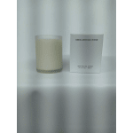 A frosted glass candle beside a white box labeled Smoldering Rose.