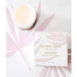 Scented candle in a jar beside a boxed coaster set