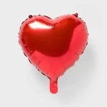 Red heart-shaped foil balloon on a plain background