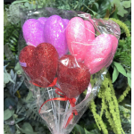 Heart-shaped glitter balloons in pink, purple, and red wrapped in clear plastic