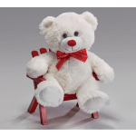 White teddy bear with a red bow sitting on a small red chair