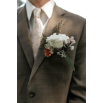 White rose boutonniere on a brown suit jacket