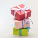 Stack of three wrapped gift boxes tied with ribbons