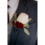 White rose boutonniere with red roses on a suit lapel