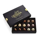 Open black Godiva truffle box showing assorted round chocolates in rows