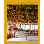 Book cover showing a woman holding a crate of flowers in a room filled with hanging dried blooms.