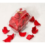 Clear gift box filled with red rose petals and tied with gold ribbon