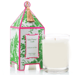 White candle in a glass tumbler beside a patterned box with tassel
