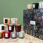 Assorted scented candles in textured glass jars with decorative boxes